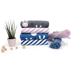 Stack of tygdrommar fabric in 4 designs. Grey fabric with white bunnies, blue fabric with white bunnies, lilac diagonal stripe and blue diagonal stripe
