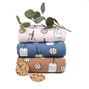 Stack of Tygdrommar Milk N Cookies Organic Cotton fabric in Light Pink, blue and sandstorm